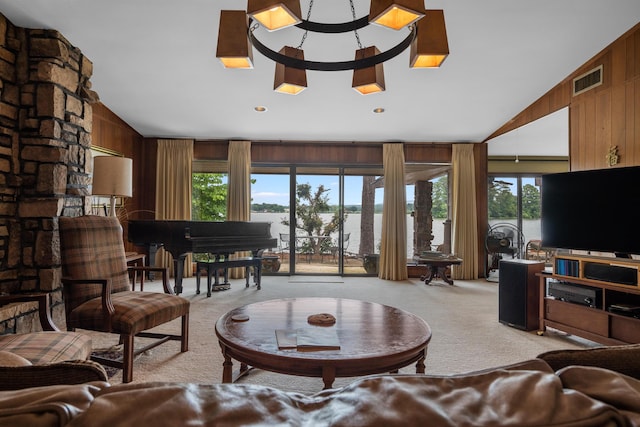 carpeted living room with lofted ceiling and wooden walls