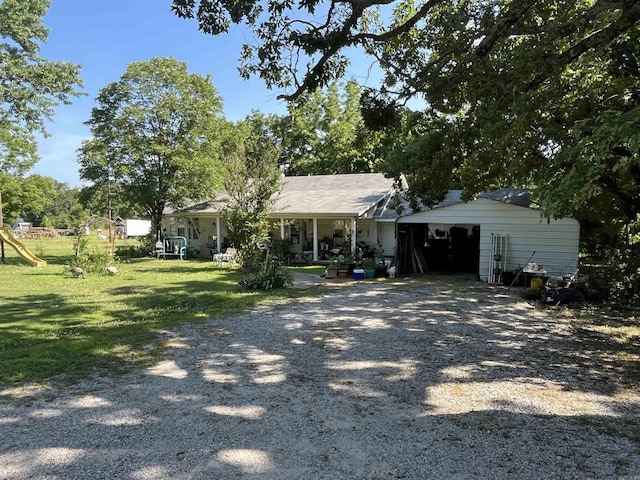 ranch-style house with a garage, a front yard, and a playground