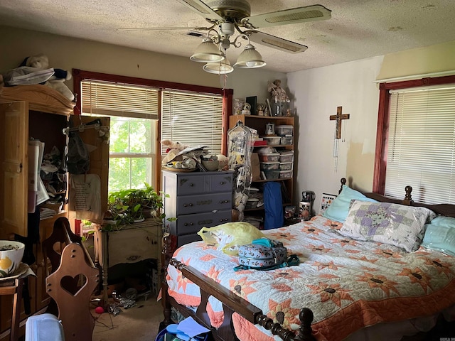 bedroom featuring a textured ceiling, carpet, and ceiling fan