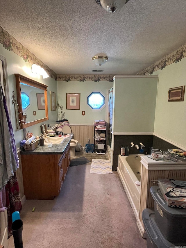 bathroom with a bathtub, a textured ceiling, and vanity