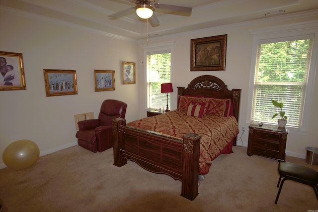 bedroom with a tray ceiling, crown molding, ceiling fan, and light colored carpet