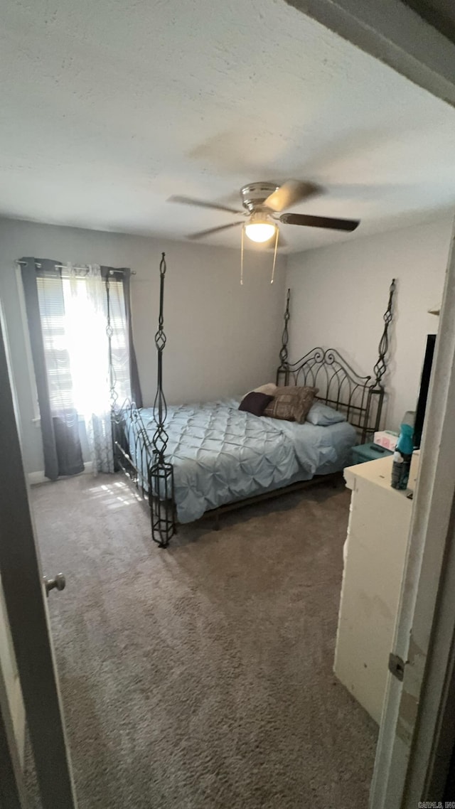 bedroom featuring dark colored carpet and ceiling fan