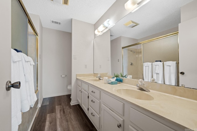 5371 Central Ave Unit L, Hot Springs, AR 71913 - full bathroom with vanity, combined bath / shower with glass door, hardwood / wood-style flooring, toilet, and a textured ceiling