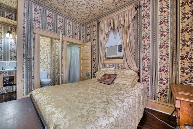 bedroom with dark hardwood / wood-style floors and connected bathroom