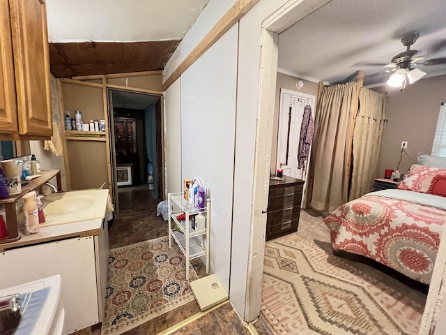 bedroom featuring ceiling fan and sink