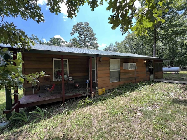 back of house featuring a wall unit AC and a wooden deck