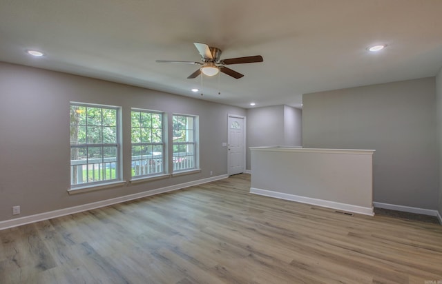 empty room with ceiling fan and light wood-type flooring