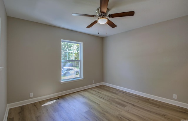 spare room with ceiling fan and light wood-type flooring