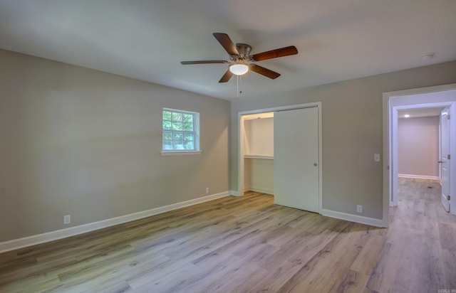 unfurnished bedroom featuring ceiling fan, a closet, and light wood-type flooring