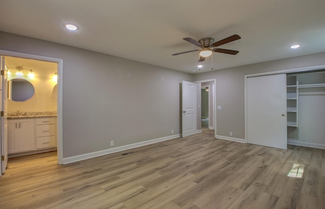 unfurnished bedroom featuring connected bathroom, sink, ceiling fan, light hardwood / wood-style floors, and a closet