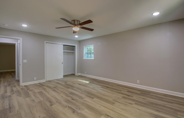 unfurnished bedroom with ceiling fan, a closet, and light wood-type flooring