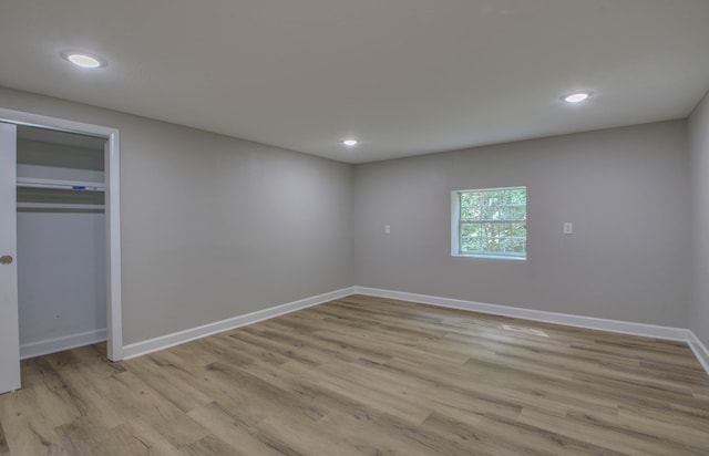 unfurnished bedroom with light hardwood / wood-style flooring and a closet