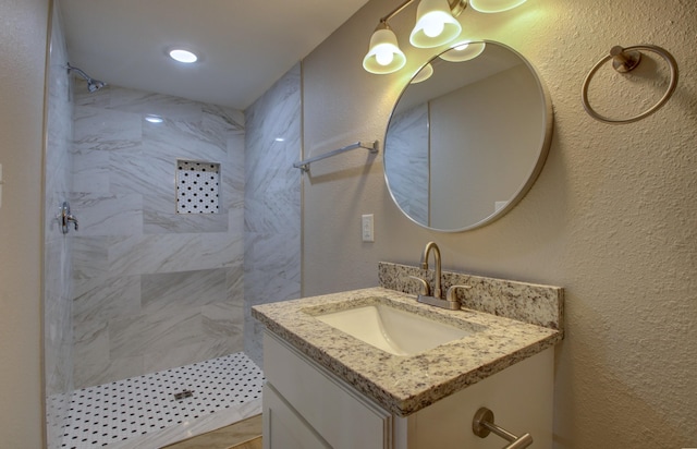 bathroom featuring a tile shower and vanity