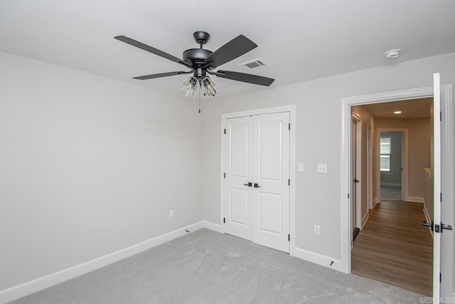 unfurnished bedroom with light carpet, a closet, and ceiling fan