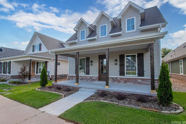 view of front of property with a porch and a front lawn