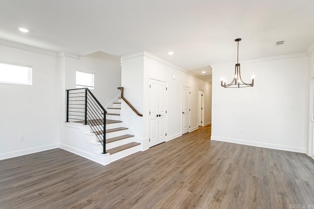 basement featuring a chandelier, ornamental molding, and dark wood-type flooring