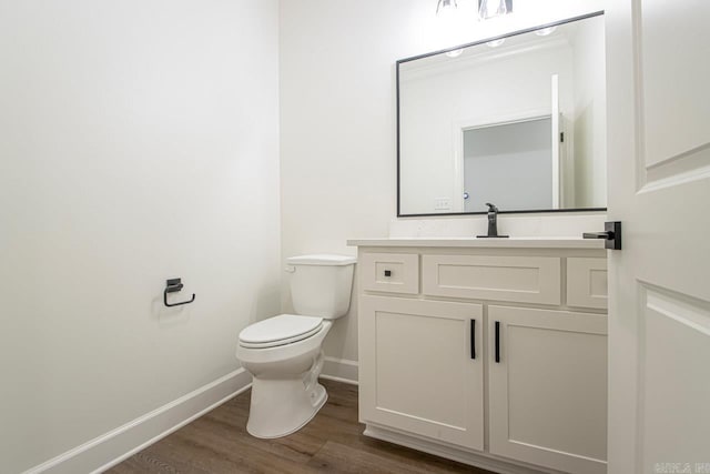 bathroom with hardwood / wood-style floors, vanity, and toilet