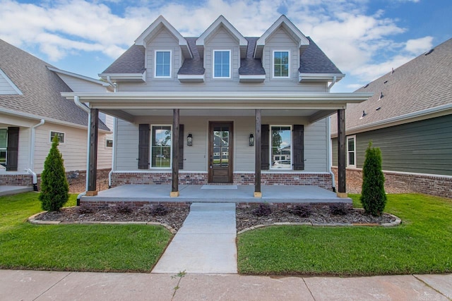 view of front of property featuring covered porch and a front yard