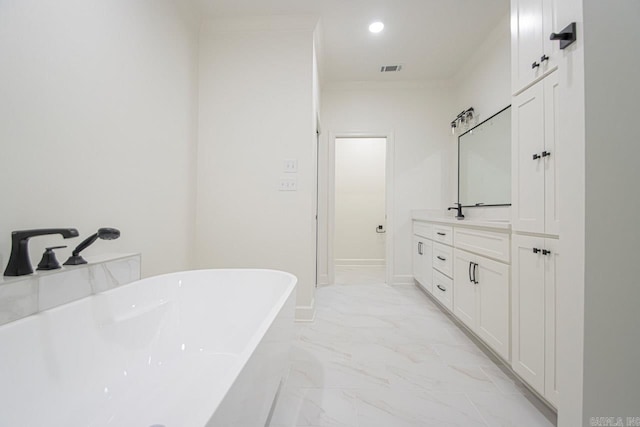 bathroom with a bathing tub, vanity, and ornamental molding