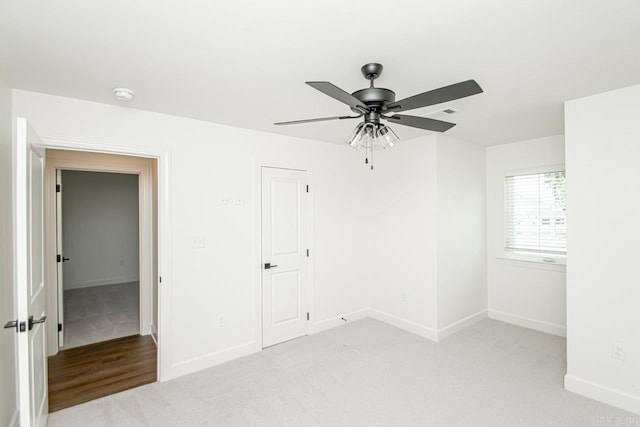 unfurnished bedroom featuring ceiling fan, a closet, and light carpet