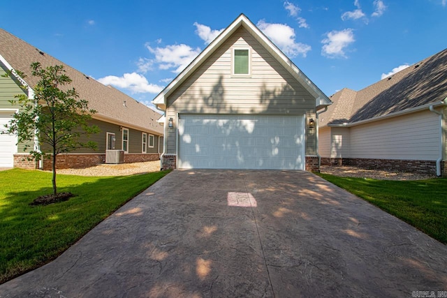 view of front property featuring central air condition unit, a front yard, and a garage