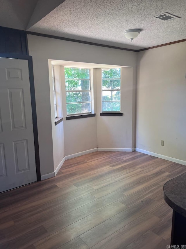 spare room featuring a textured ceiling and hardwood / wood-style flooring