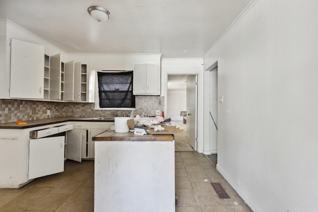 kitchen featuring dishwasher, white cabinets, decorative backsplash, ornamental molding, and light tile patterned flooring