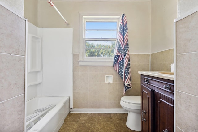 full bathroom featuring shower / bathtub combination, vanity, tile walls, and toilet