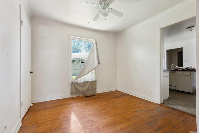 unfurnished room featuring hardwood / wood-style floors, ceiling fan, and crown molding