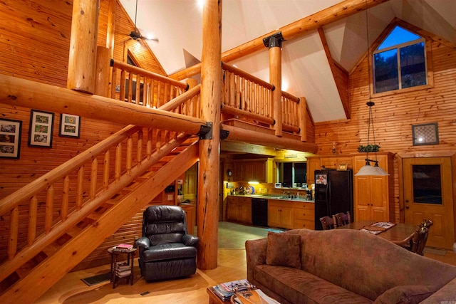 living room with wood walls, sink, and high vaulted ceiling