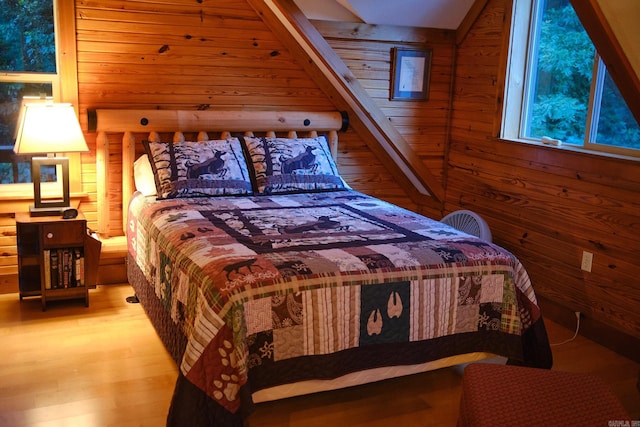 bedroom with wood walls and hardwood / wood-style floors