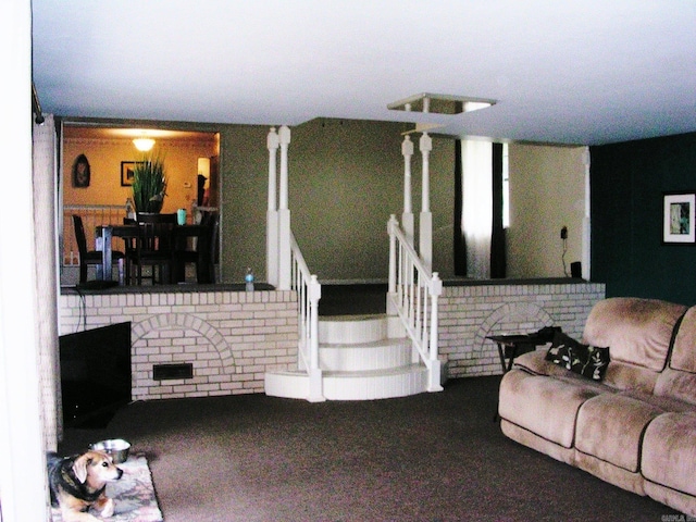 living room featuring carpet and a brick fireplace