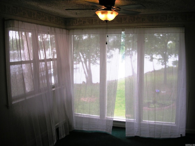 unfurnished sunroom featuring ceiling fan