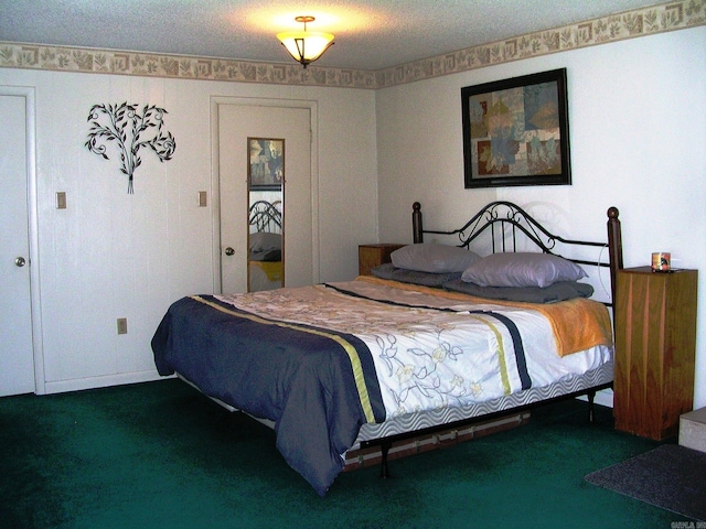 bedroom featuring dark carpet and a textured ceiling