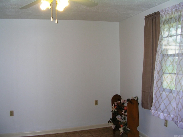 spare room featuring a textured ceiling and ceiling fan