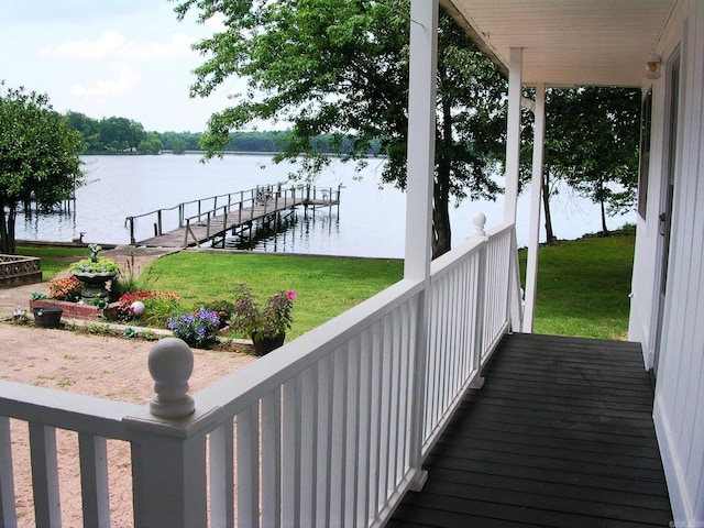 view of dock with a yard and a water view