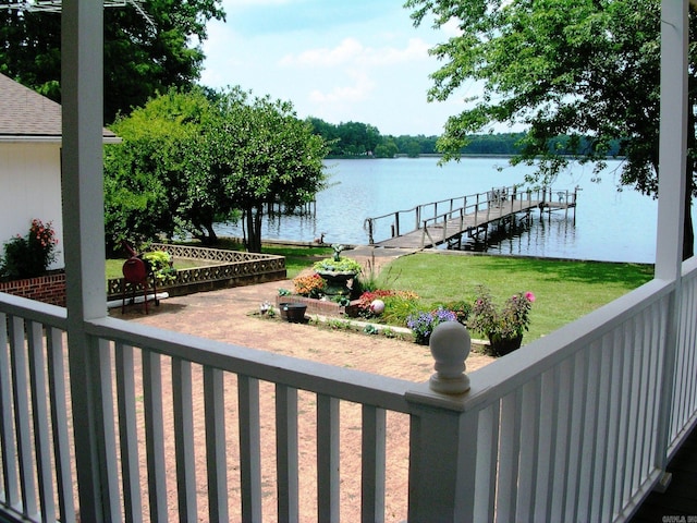 view of dock featuring a lawn and a water view