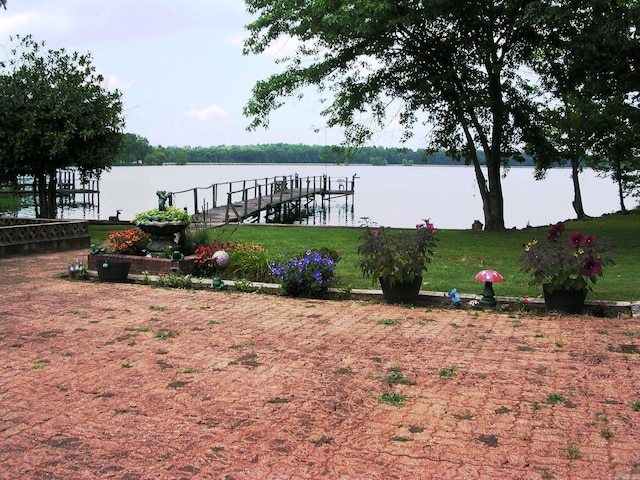 dock area with a yard and a water view