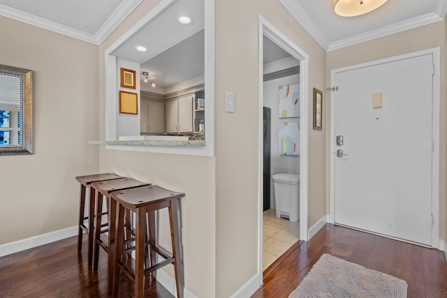 entrance foyer with dark wood-type flooring and ornamental molding