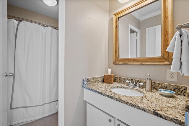 bathroom with tile patterned flooring, ornamental molding, and vanity