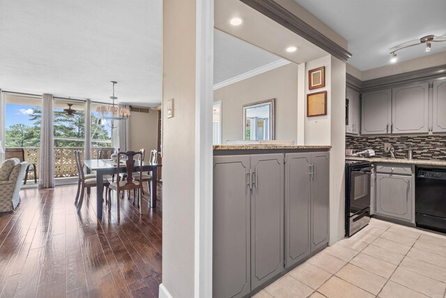 kitchen with gray cabinetry, a healthy amount of sunlight, backsplash, and black appliances