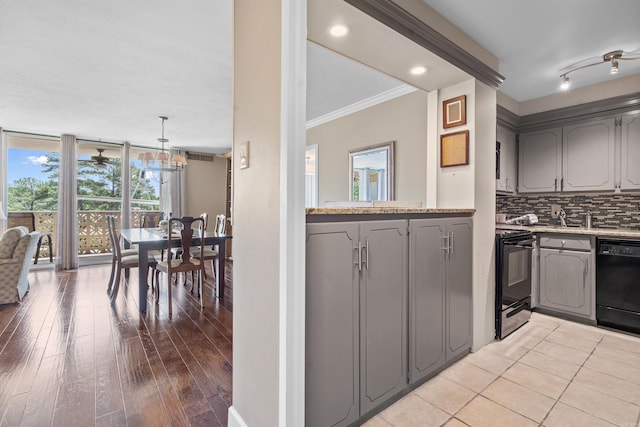 kitchen featuring gray cabinets, pendant lighting, backsplash, black appliances, and crown molding