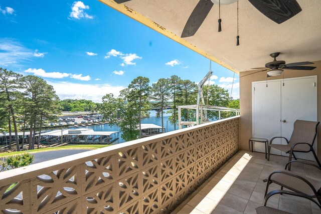 balcony with a water view and ceiling fan