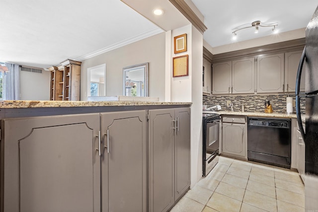 kitchen with electric range, backsplash, rail lighting, dishwasher, and light tile floors