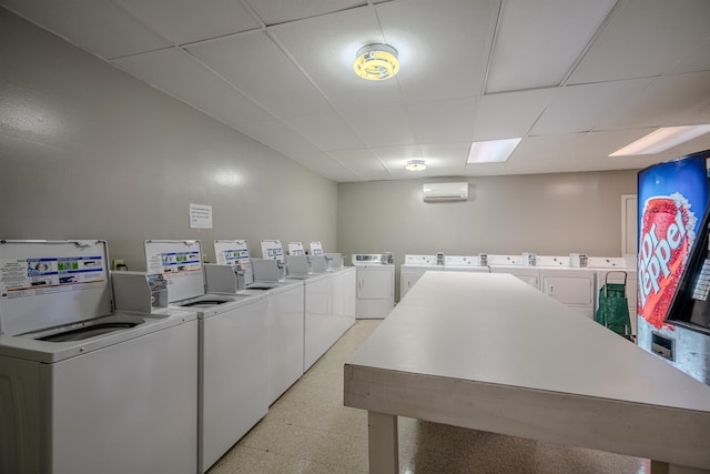 laundry room with a wall mounted AC and washing machine and clothes dryer