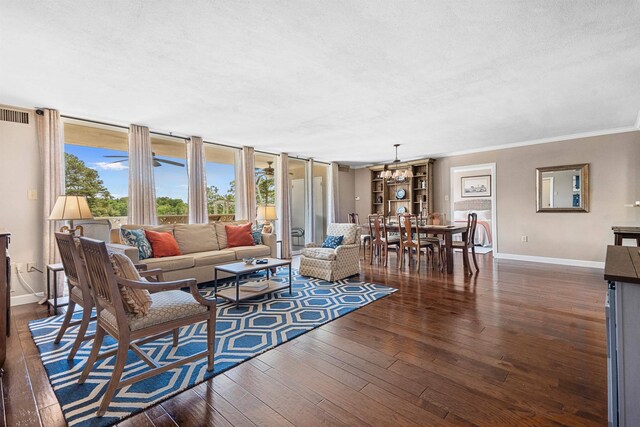 living room with crown molding, dark wood-type flooring, and a textured ceiling