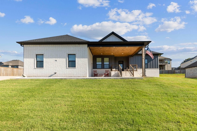 rear view of house featuring a lawn and a patio area