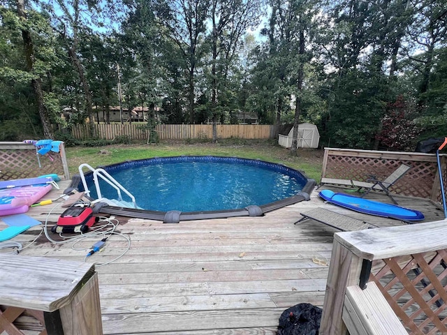 view of pool featuring a deck and a shed