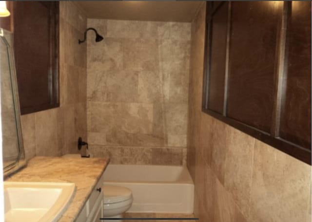 full bathroom with tiled shower / bath combo, vanity, and toilet