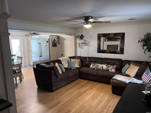 living room featuring hardwood / wood-style flooring, crown molding, and ceiling fan